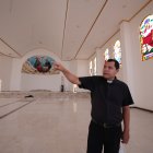 El padre Omar Almeida explica lo que falta por hacer. En el tumbado destacan unas rositas rojas pintadas a mano.