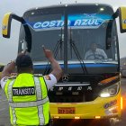 Agente de la CTE comprueba el estado de las luces de un bus de transporte de pasajeros.