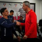 El DT brasileño Tiago Nunes (d) saluda con el ofensivo Alexander Alvarado.