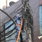 Un trabajador retira los cables inservibles en un tramo de la avenida Rodrigo de Chávez, en el sur de Quito.