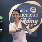 La analista de la Dirección de Turismo de Negocios, Gabriela Flores, posa con el trofeo con el que Quito, la capital de Ecuador, fue galardonada como destino romántico y de turismo de reuniones durante la ceremonia de los premios Latin America Wedding Awards (LAWA), celebrada este miércoles en el hotel Jaragua, en Santo Domingo (República Dominicana).