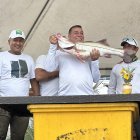 El equipo Caña y Carrete, ganadores del festival, levantan en alto el robalo capturado frente a la costa de Atacames.