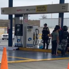 El cuerpo del joven quedó tendido en la estación de servicio donde trabajaba, tras recibir un disparo en la cabeza. Agentes de Criminalística acordonaron la zona para levantar indicios.
