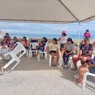 Los familiares aguardan por noticias de los pescadores bajo una carpa en el muelle de San Mateo