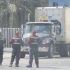 Guardias de seguridad de las terminales de la isla Trinitaria custodian las cargas que llegan.