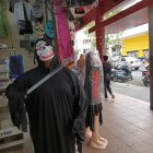 Un vendedor con una máscara de monstruo tuerto atrae al público.