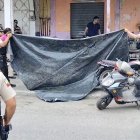 Agentes de la Policía Nacional cubren con un plástico el cuerpo del hombre asesinado este jueves en Esmeraldas.