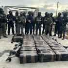 Agentes policiales custodian los bultos de cocaína incautados durante la operación “ISLARION”, ejecutada en un centro de acopio en Esmeraldas.