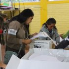 Personal del CNE alista material de votación en un centro de sufragio.