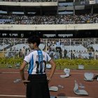 Un aficionado de Lionel Messi yace entre sillas y objetos rotos en el estadio Salt Lake de Calcuta.