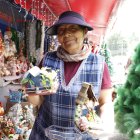 Gladys sostiene dos de sus creaciones elaboradas con material reciclado.