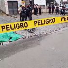 Agentes policiales acordonan la escena donde un hombre fue asesinado a tiros en La Concordia; la motocicleta quedó junto al cuerpo, cubierto por una lona verde.