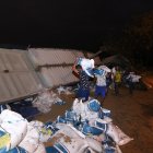 Trabajadores descargan sacos de alimento para camarón del tráiler siniestrado.