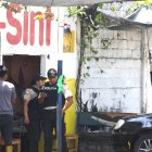 Los policías levantan evidencias en el lugar del crimen.