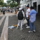 Asistentes a la marcha por Aquiles Álvarez junto a desechos de cerveza en el centro de Guayaquil.
