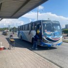 En la parada del puerto de Esmeraldas, un bus de la coop. Las Palmas recoge pasajeros en medio de la dinámica urbana y el comercio callejero.