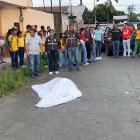 Estudiantes y docentes rodean el cuerpo de la profesora Diana Alcívar, asesinada a pocos metros del colegio donde laboraba.