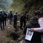 Recreación: familiares y voluntarios participan en una jornada de búsqueda en una zona montañosa, mientras una madre sostiene la fotografía de su hijo desaparecido.
