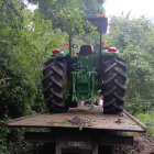 El automotor agrícola recuperado junto a los trabajadores.