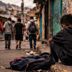 Recreación: niño observa a otros adolescentes en una calle de barrio vulnerable, en una escena que refleja la falta de oportunidades que enfrentan muchos menores.