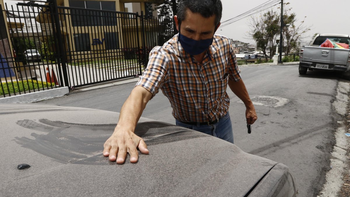Un ciudadano de Guayaquil retira las cenizas del volcán en un barrio de Guayaquil.