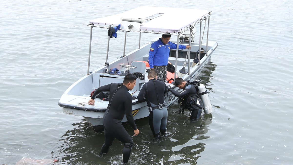Buzos del Grupo de Intervención y Rescate (GIR), de la Policía Nacional, realizan la búsqueda del muchacho.