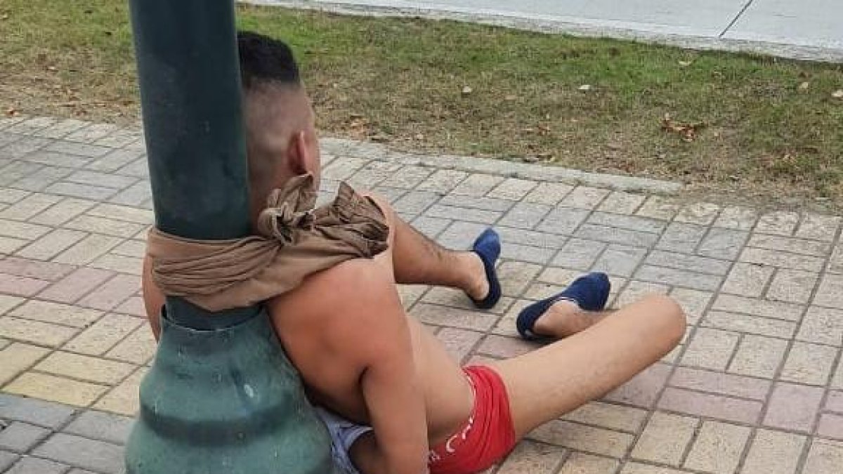 El hombre fue amarrado a un poste de alumbrado público. Utilizaron el pantalón para atarlo.