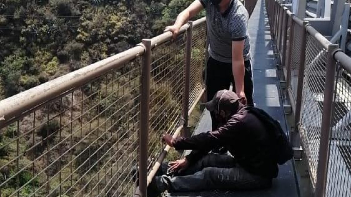 Uno de los conductores que vio la escena sostenía al hombre para que no se arrojara.