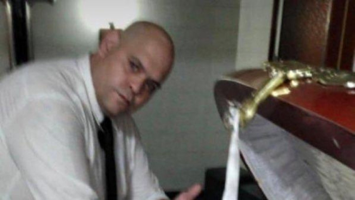 La foto de la discordía en el mundo, un empleado de la funeraria y el cuerpo de Diego Armando Maradona.