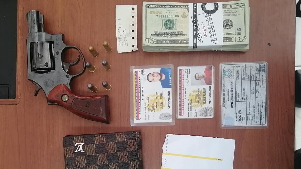 Un arma, el dinero recuperado y documentos de los implicados fueron mostrados por la Policía.