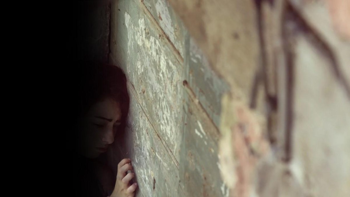 Sobre un muro de bloque y cemento, la menor de edad hablaba con sus vecinas.