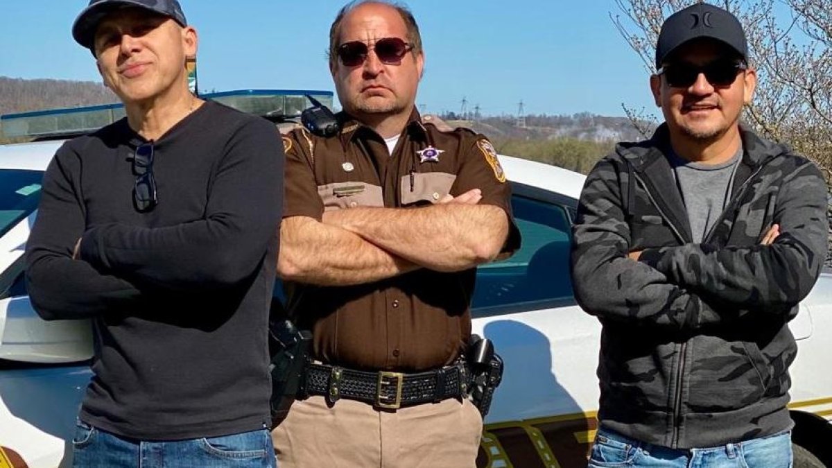 Gerardo Mejía y su pana Fausto Zúñiga flanquean al policía norteamericano Larry Pancake.