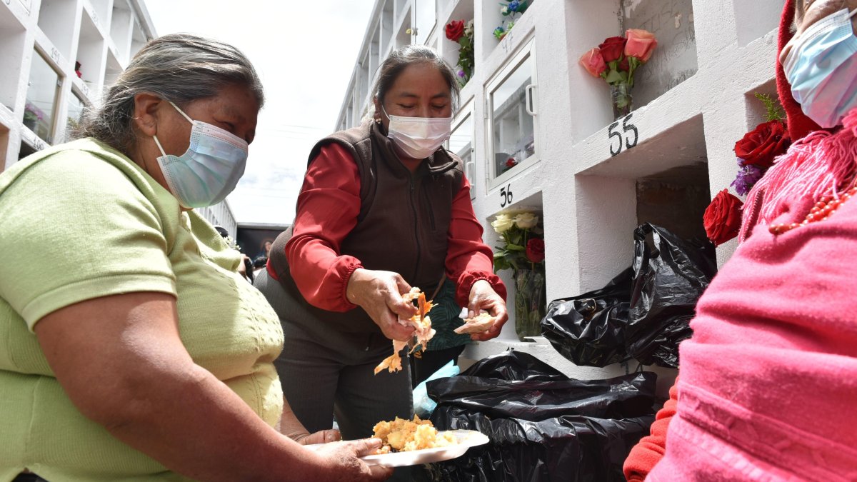 Varias personas se sentaron junto a las tumbas para alimentarse.