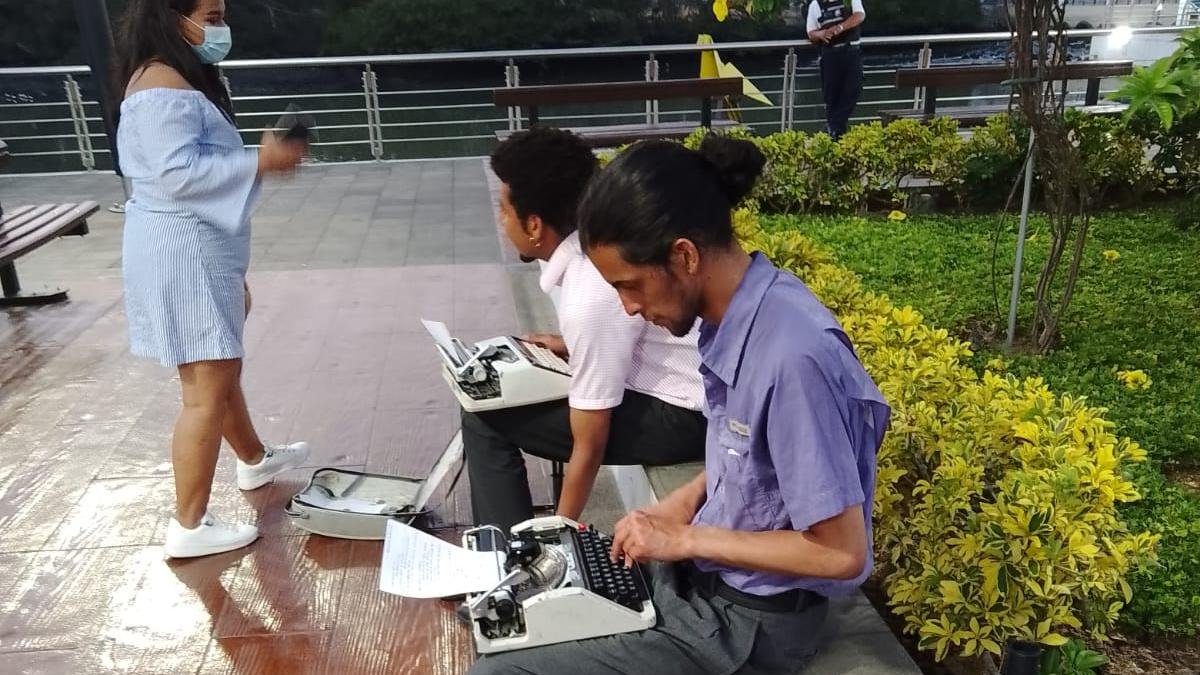 Edward Guillén (centro)y su comapñero Jesús García atendiendo pedidos de poesías en el Puente Zig Zag. 