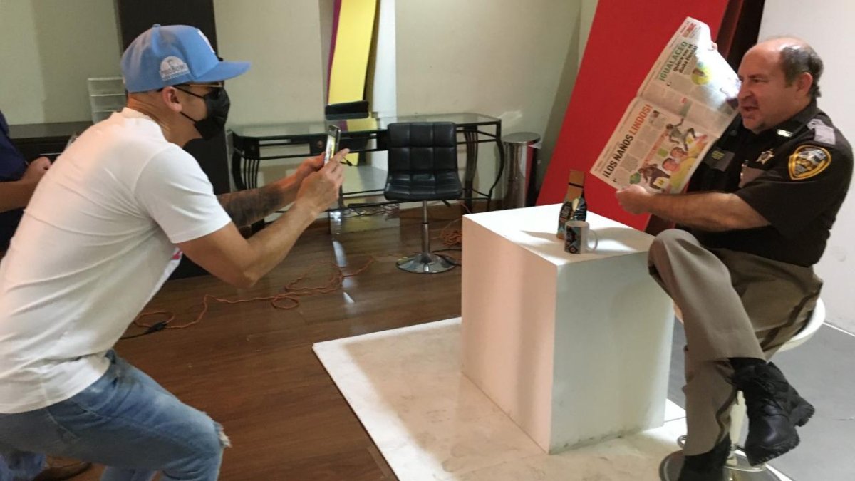 En rapero ecuatoriano Gerardo Mejía le toma una foto a Larry Pancake, mientras muestra la sección Deportiva de EXTRA.