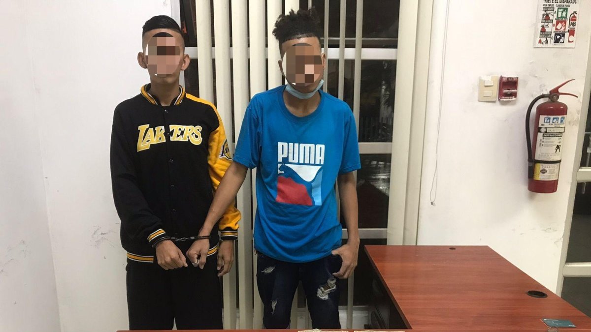 Uno de los detenidos le hizo señas al otro para advertirle de la presencia policial.