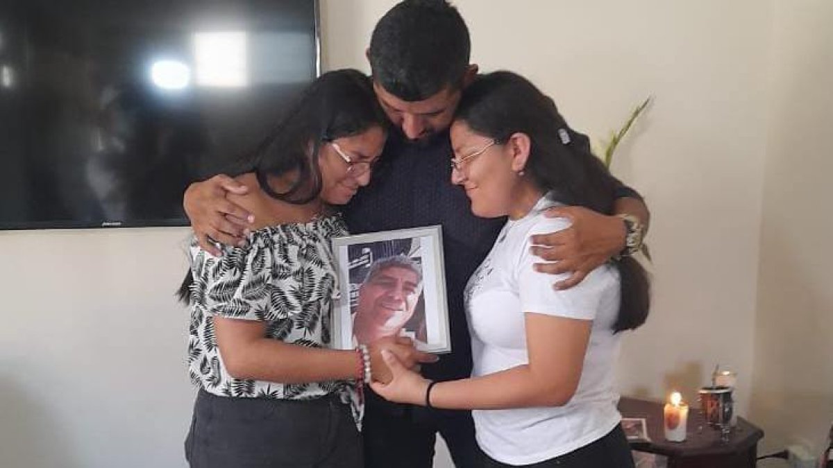Los tres hijos de la víctima sostienen un portarretrato con la imagen de su padre. Está sonriente. Así lo recuerdan.