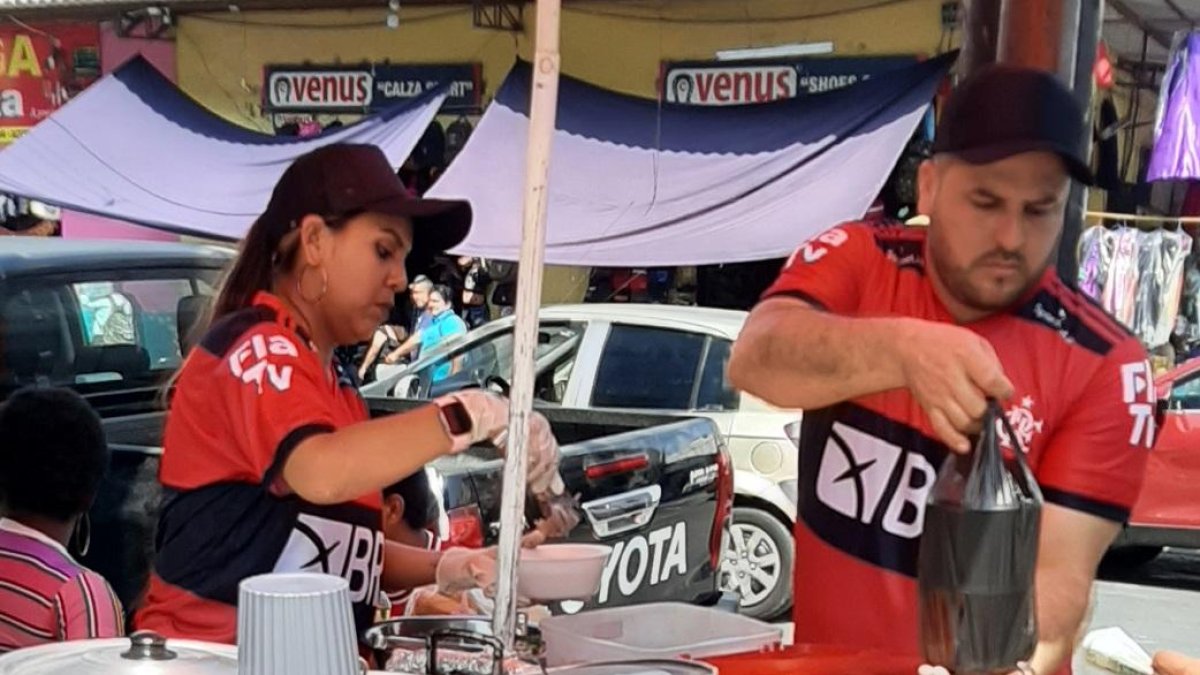En pleno centro de Guayaquil, Yomaira y Tony, dos ecuatorianos con la camiseta de Flamengo, venden el buen encebollado.