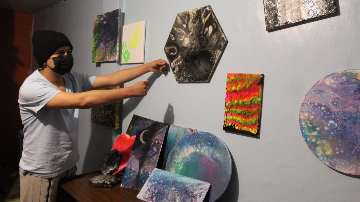 Xavier muestra los cuadros que ha pintado y que pretende vender en 30 dólares.