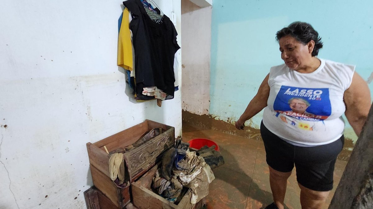 Beatriz Amaguaña revisa parte de la ropa que pudo rescatar de entre el lodo, para ver qué le puede servir todavía.