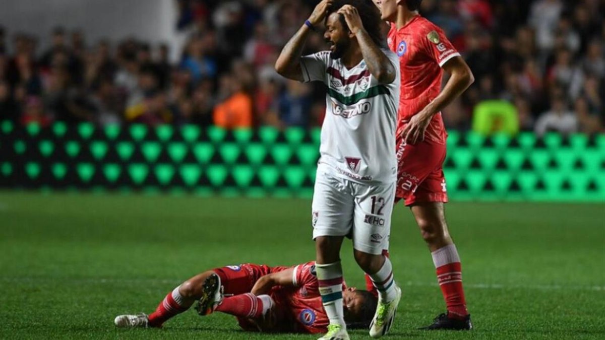Luciano Sánchez (suelo) sufrió una terrible lesión por parte del brasileño Marcelo, quien se toma la cabeza al observar cómo quedó la pierna del defensa argentino.