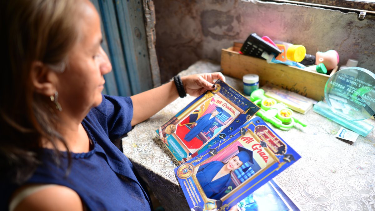 María Cañarte observa orgullosa las fotos que le tomaron el día de su graduación de bachiller