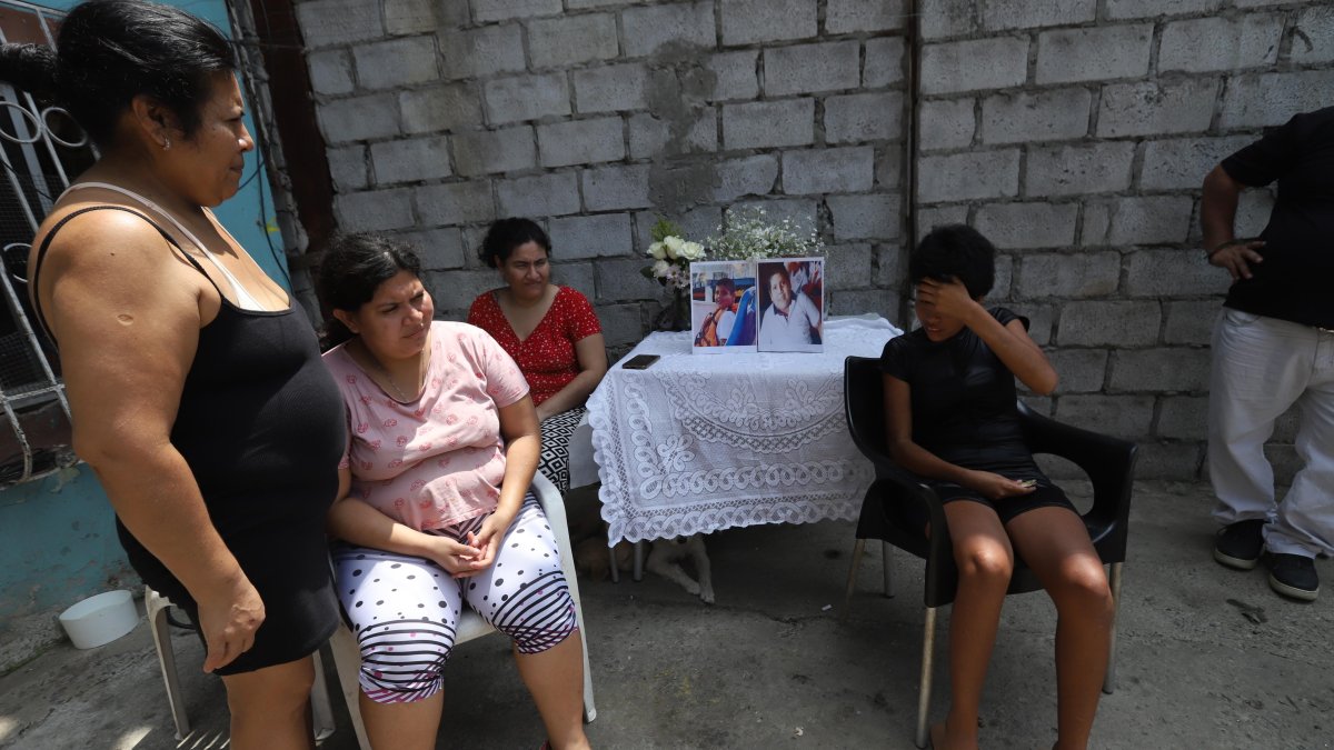 María (de pie), acompañada de sus tres hijas quienes son personas con discapacidad, observa la fotografía de su amado Joaquín.