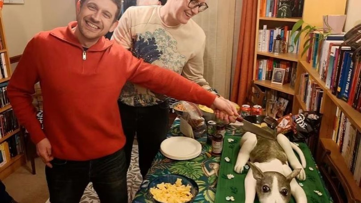 El esposo de Anna Railton, Chris Smowton cortando el pastel de su mascota