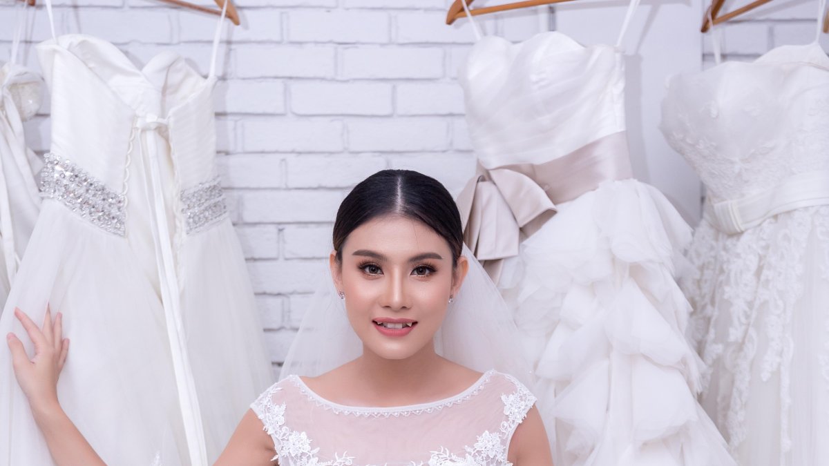 Asian young woman bride trying on wedding dress at modern wedding