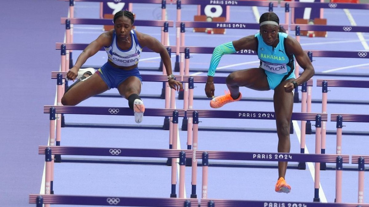 La ecuatoriana Maribel Caicedo (i) junto a Charisma Taylor de Bahamas en semifinales de 100 metros vallas