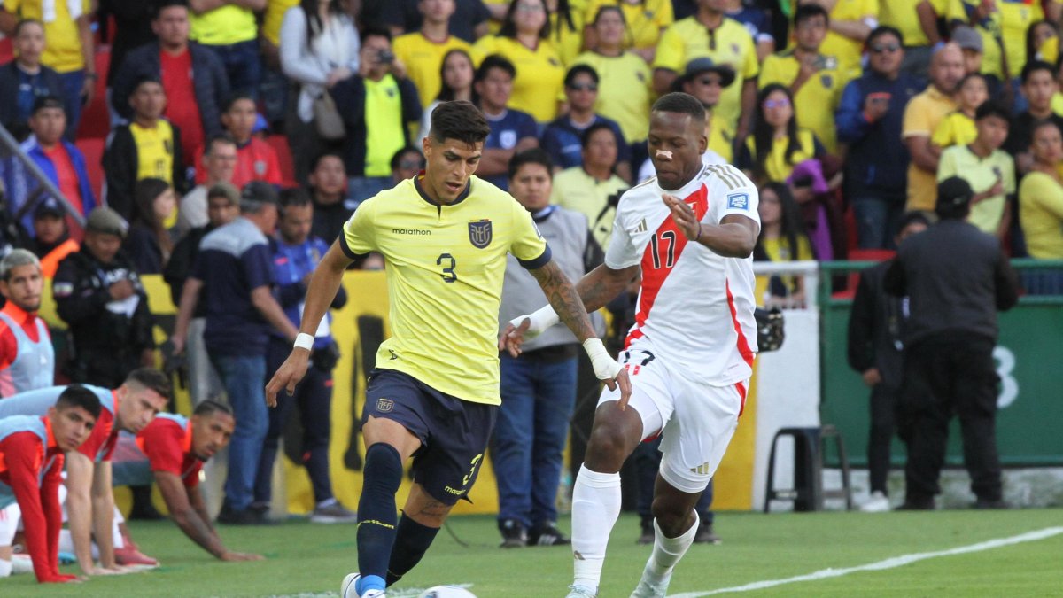 Piero Hincapié (i), defensa de Ecuador, disputa una pelota con Luis Advíncula, lateral de Perú.