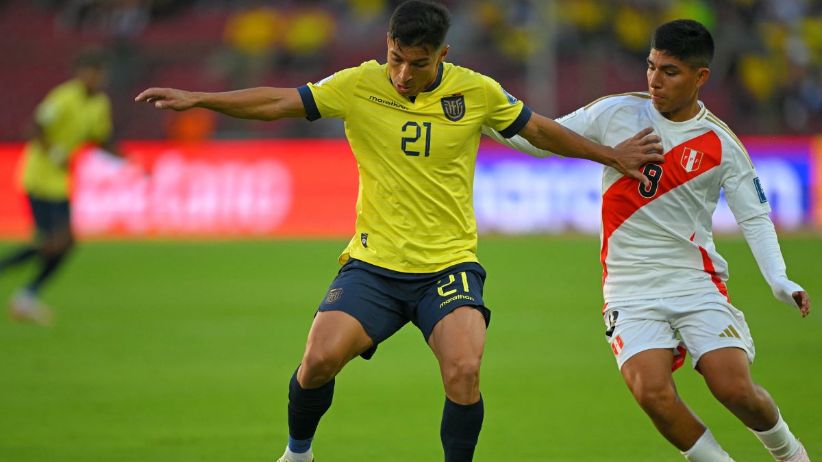 Alan Franco y Piero Quispe luchan durante el partido de las eliminatorias sudamericanas entre Ecuador y Perú en el estadio Rodrigo Paz Delgado de Quito.