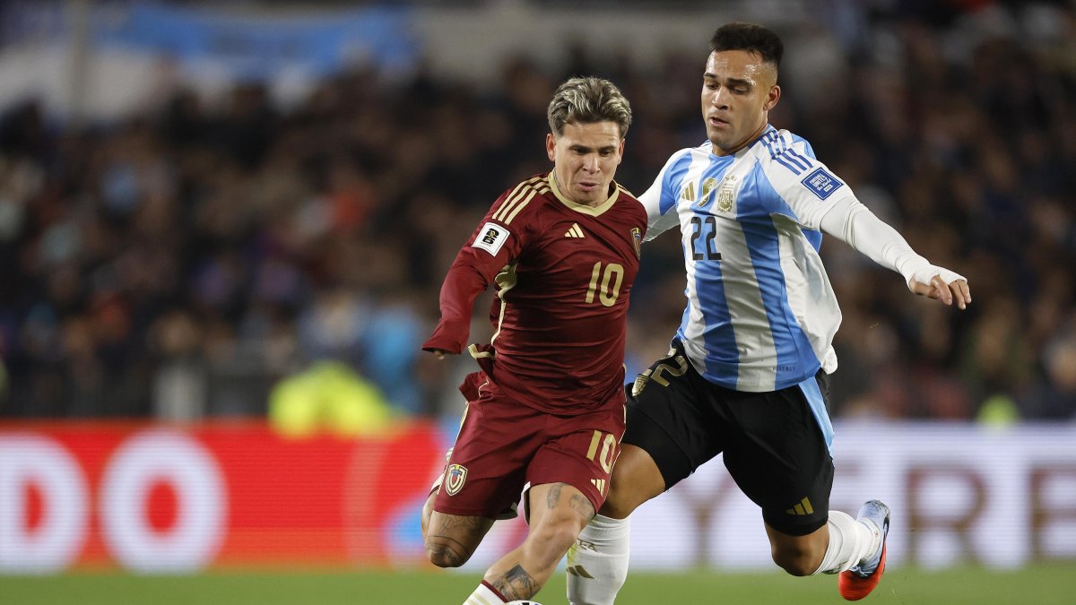 Lautaro Martínez (d), de Argentina, disputa el balón con Yeferson Soteldo, de Venezuela, en el partido por las eliminatorias en el estadio Monumental en Buenos Aires.