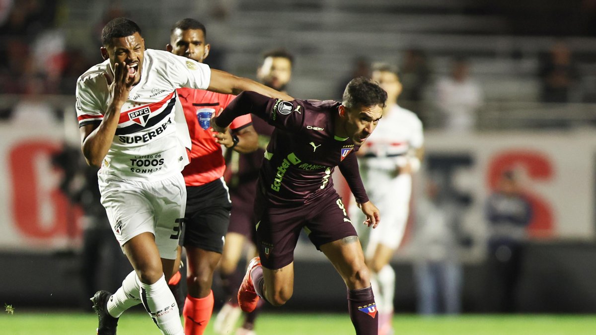Sabino (i) de Sao Paulo disputa el balón con Lisandro Alzugaray de LDU, en un partido de cuartos de final de la Copa Libertadores.